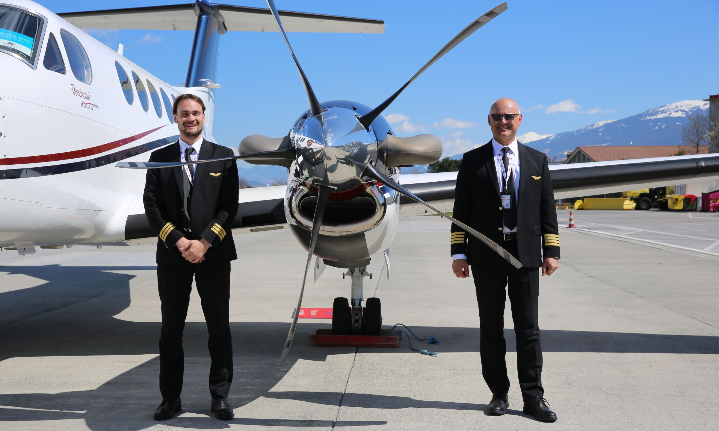 Alpine Wings flight crew standing beside a King Air aircraft.